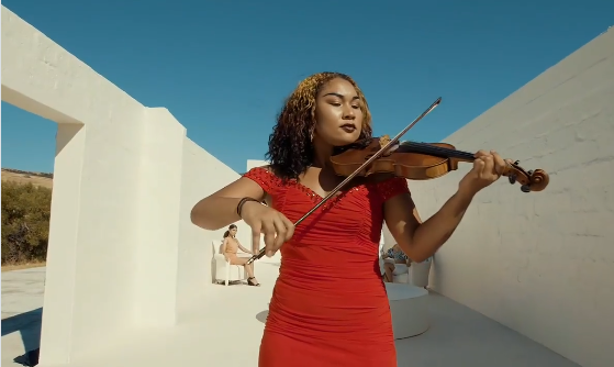 Estée playing the violin in a red dress, video performance on Instagram